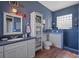 Nautical-themed bathroom with blue walls, updated vanity, glass block window, and tiled walk-in shower at 4725 County Road 121D, Wildwood, FL 34785