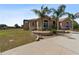 Inviting single-story home with decorative stone accents, arched windows, and lush landscaping at 4725 County Road 121D, Wildwood, FL 34785