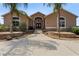 Inviting home exterior with well-manicured landscaping, stone accents, and a charming covered entryway at 4725 County Road 121D, Wildwood, FL 34785