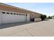 Two-car garage with white door featuring adjacent door entrance, and extra-long concrete driveway at 4725 County Road 121D, Wildwood, FL 34785