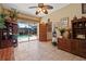 Cozy living room showcasing tile floors, wooden furniture and an open door to the pool area at 4725 County Road 121D, Wildwood, FL 34785