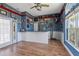 Living room featuring laminate flooring, bright lighting, fishing decor, and large windows at 4725 County Road 121D, Wildwood, FL 34785