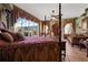Main bedroom with canopy bed, decorative window treatments, and serene views of the pool at 4725 County Road 121D, Wildwood, FL 34785