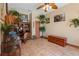 Bright office with a wooden desk, decorative plants, bird cage, and a wooden storage chest at 4725 County Road 121D, Wildwood, FL 34785