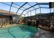 Backyard pool area featuring a rock waterfall and a screened enclosure at 4725 County Road 121D, Wildwood, FL 34785