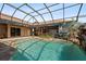 Lovely screened-in pool area features a waterfall, tropical plants and a tiki bar at 4725 County Road 121D, Wildwood, FL 34785