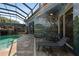 Screened pool with waterfall feature and stone patio, surrounded by painted murals and lounge chairs at 4725 County Road 121D, Wildwood, FL 34785
