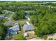 Aerial view of a single-Gathering home with a screened-in lanai, lush landscaping, and a detached garage at 5195 Sw 128Th Street Rd, Ocala, FL 34473