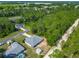 Aerial view of a single Gathering home showing a treed backyard and a long, gravel drive at 5195 Sw 128Th Street Rd, Ocala, FL 34473