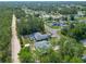 Aerial view of a neighborhood with single-Gathering homes, lush trees, and a gravel road at 5195 Sw 128Th Street Rd, Ocala, FL 34473