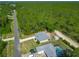 Aerial view of a single-Gathering home with a long, paved drive showing the home's roof and a treed yard at 5195 Sw 128Th Street Rd, Ocala, FL 34473