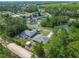 Aerial view of a neighborhood with single-Gathering homes, lush trees, and a gravel road at 5195 Sw 128Th Street Rd, Ocala, FL 34473