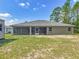 Backyard view featuring a covered porch and well-maintained exterior, perfect for outdoor relaxation and entertaining at 5195 Sw 128Th Street Rd, Ocala, FL 34473