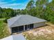 Aerial shot of the backyard with a gray roof and screened in patio and a utility shed in a wooded setting at 5195 Sw 128Th Street Rd, Ocala, FL 34473