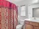 Well-lit bathroom features a sink vanity and shower with curtain at 5195 Sw 128Th Street Rd, Ocala, FL 34473
