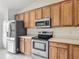 Modern kitchen with stainless steel appliances, wood cabinets, and ample counter space at 5195 Sw 128Th Street Rd, Ocala, FL 34473