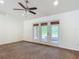 Spacious living room with carpeting, ceiling fan, and French doors leading to outside at 5195 Sw 128Th Street Rd, Ocala, FL 34473
