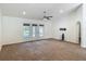Spacious living room with carpeting, ceiling fan, and French doors leading to outside at 5195 Sw 128Th Street Rd, Ocala, FL 34473
