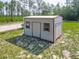 Utility outbuilding offering extra storage or workspace located within a partially wooded homesite with gravel drive at 5195 Sw 128Th Street Rd, Ocala, FL 34473