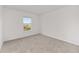A neutral carpeted bedroom offers a large window with views of the community at 5894 Sw 77Th Ct, Ocala, FL 34481