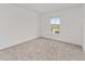 A neutral carpeted bedroom features a large window with a view of the community at 5894 Sw 77Th Ct, Ocala, FL 34481