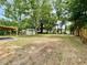 Large backyard featuring a shed and covered patio surrounded by mature trees and partial fencing at 6134 Se Stetson Rd, Belleview, FL 34420