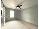 Spacious bedroom with neutral carpet, a modern ceiling fan, and ample natural light at 6134 Se Stetson Rd, Belleview, FL 34420