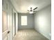 A cozy carpeted bedroom featuring a ceiling fan and natural light from a window at 6134 Se Stetson Rd, Belleview, FL 34420