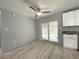 Bright dining area featuring wood-look floors, ceiling fan, sliding glass doors, and white cabinets at 6134 Se Stetson Rd, Belleview, FL 34420