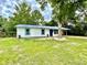 Charming single-story home with blue metal roof, white siding, and a mature tree in the front yard at 6134 Se Stetson Rd, Belleview, FL 34420