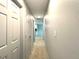 Hallway featuring neutral carpet and multiple doors at 6134 Se Stetson Rd, Belleview, FL 34420