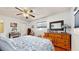 Cozy bedroom featuring a ceiling fan, dresser and mirror, and warm wood floors at 6468 Sw 107Th Pl, Ocala, FL 34476