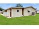The back exterior shows a well-kept lawn and siding, with an access door at 6468 Sw 107Th Pl, Ocala, FL 34476