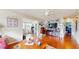 Open living room leading into the office featuring wood floors and comfortable seating at 6468 Sw 107Th Pl, Ocala, FL 34476
