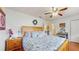 Comfortable main bedroom with wooden furnishings, ceiling fan, and en-suite bathroom at 6468 Sw 107Th Pl, Ocala, FL 34476