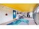 Inviting screened patio with bright yellow ceiling, colorful decor, and comfortable seating area at 6468 Sw 107Th Pl, Ocala, FL 34476