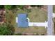 An aerial view showcasing the roof, driveway, and surrounding grounds at 7299 Sw 202 Ct, Dunnellon, FL 34431
