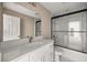 Bathroom featuring double sinks, granite countertop, modern fixtures and glass enclosed shower at 7299 Sw 202 Ct, Dunnellon, FL 34431