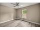 A well lit bedroom with a ceiling fan, sunlit window, and vinyl flooring at 7299 Sw 202 Ct, Dunnellon, FL 34431