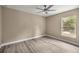 A spacious bedroom with a ceiling fan, and a sunlit window, complemented by vinyl flooring at 7299 Sw 202 Ct, Dunnellon, FL 34431