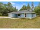 A view of the side and front of a delightful single-story home with an attached garage and spacious yard at 7299 Sw 202 Ct, Dunnellon, FL 34431
