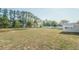 Spacious backyard with room to roam, framed by mature trees and a white fence for privacy at 7475 Se 105Th Pl, Belleview, FL 34420