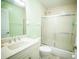 Bright bathroom featuring a shower-tub combo with sliding glass doors and white vanity at 7475 Se 105Th Pl, Belleview, FL 34420