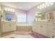 Bright bathroom featuring a corner bathtub, dual sinks, and large mirror at 7475 Se 105Th Pl, Belleview, FL 34420
