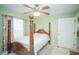 Bedroom with a four-poster bed, green walls, ceiling fan, and tile floors at 7475 Se 105Th Pl, Belleview, FL 34420