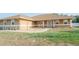 Charming home's front yard features lush grass, a small gravel area, and rocking chairs at 7475 Se 105Th Pl, Belleview, FL 34420