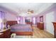 Spacious main bedroom with wood-look floors, tray ceilings, and a ceiling fan at 7475 Se 105Th Pl, Belleview, FL 34420