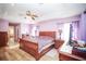 Comfortable main bedroom featuring wood-look floors, a ceiling fan, and an ensuite bath at 7475 Se 105Th Pl, Belleview, FL 34420