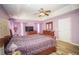 Comfortable main bedroom with wood-look floors, a ceiling fan, and tray ceilings at 7475 Se 105Th Pl, Belleview, FL 34420
