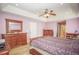 This main bedroom is spacious, with wood-look floors and an ensuite bathroom at 7475 Se 105Th Pl, Belleview, FL 34420